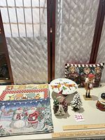 Full lot overview showing pillow, nutcracker, snow globe, snowman, tree, plate and placemats