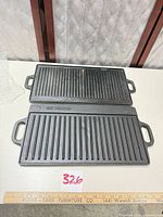 Two Old Mountain cast iron grill plates, ridged side up, showing size and handles