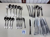 Full set laid out showing groupings of forks, spoons, loose knives and sealed knives