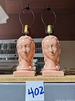 Front view showing both matching pink ceramic lady head lamps with harps and sockets