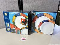 Two boxed Henny & Penny stoneware sets on table