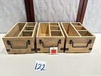 Front view of three matching wooden organizers with metal handles