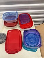 Stacks of plastic containers and assorted coloured lids
