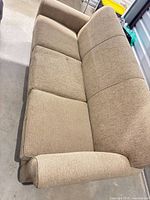 Front angled view of beige three-seat sofa showing seat and back cushions