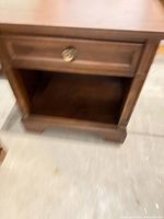 Front view showing drawer with brass knob and open cubby