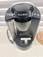 Front view of Keurig brewer showing brand logo and drip tray