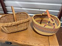 Rectangular wicker basket and round Bolga basket side by side on table