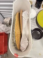 Two woven wicker chargers and wrapped items inside tall container