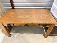 Full view of oak writing desk showing overall design and three drawers