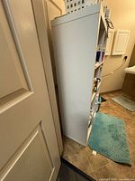 Side view of tall white cube shelving unit beside door