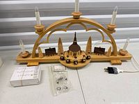 Full view of wooden Schwibbogen arch with five candle lights, spare bulbs, adapter and box