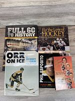 All five books laid out on wooden surface showing covers