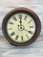 Front view of round wooden wall clock