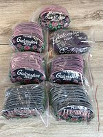 Six bagged stacks of embroidered patches showing two color variants for Galveston 2005 and one for Leesburg 2007