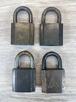 Front view of four AA padlocks showing logo and wear
