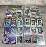 Overview of two stacks of sleeved baseball cards showing various teams and players