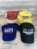 All four caps laid out: Cardinals, Florida, Giants, Red Sox