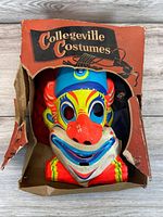 Mask inside torn Collegeville Costumes box