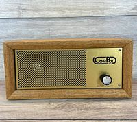 Front view showing grille, logo, control knob