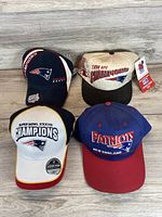 Four Patriots caps displayed