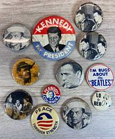 All eleven pinback buttons arranged on wood surface