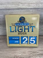 Front of Schlitz Light Beer calendar showing logo and date rollers