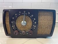 Front view showing dial, knobs, speaker grille