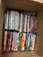 Top view of box showing rows of DVD cases with assorted titles