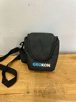 Front of black Geokon carrying case with strap