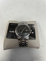 Front view of Oceannaut wristwatch on cushion with warranty card