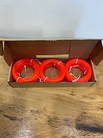 Open box showing three of the nine orange twisted line bundles