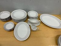 All 32 pieces grouped on table showing plates, bowls, platters, gravy boat and creamer