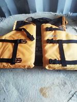 Front view of yellow Cabela's life vest with three black straps