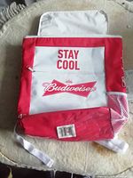 Front of Budweiser cooler backpack showing logo, color, side mesh pocket