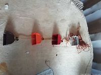 Full view of door hanger showing four colored square bells on twine