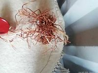 Close-up of raffia bundle and red half-bucket on hanger