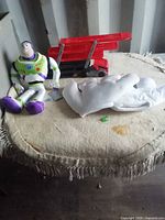 Overview of Buzz Lightyear plush, Mickey gloves and Hot Wheels truck on table