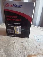 Front of CargoMaster rainproof rooftop bag box displaying brand, product name, dimensions 39x32x18 in