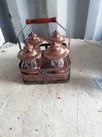 Front view of four copper-tone lanterns seated in charging platform