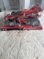 Front angled view of packaged red wind-up race car