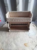 Front view of rectangular wicker wall holder showing two shelves and woven pattern