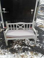 Full view of light grey wooden bench with cushion