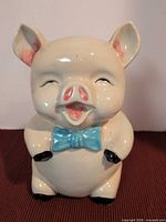 Front view of ceramic piggy bank with blue bow tie