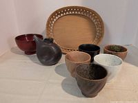Group shot showing lacquer bowl, soy dispenser, five teacups, bamboo tray