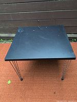 Full view of square black side table with hairpin legs
