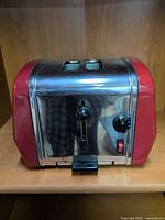 Front and side view of red and chrome VillaWare toaster with controls visible