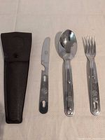 spoon, fork, knife and holster laid out to show condition and markings