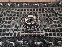 Detail of Urafiki kanga showing central emblem, animal motifs and border patterns