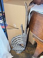 Full view of carved wooden bird-crest sculpture standing upright beside boxes