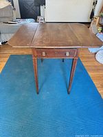 Table with leaves extended showing drawer and legs